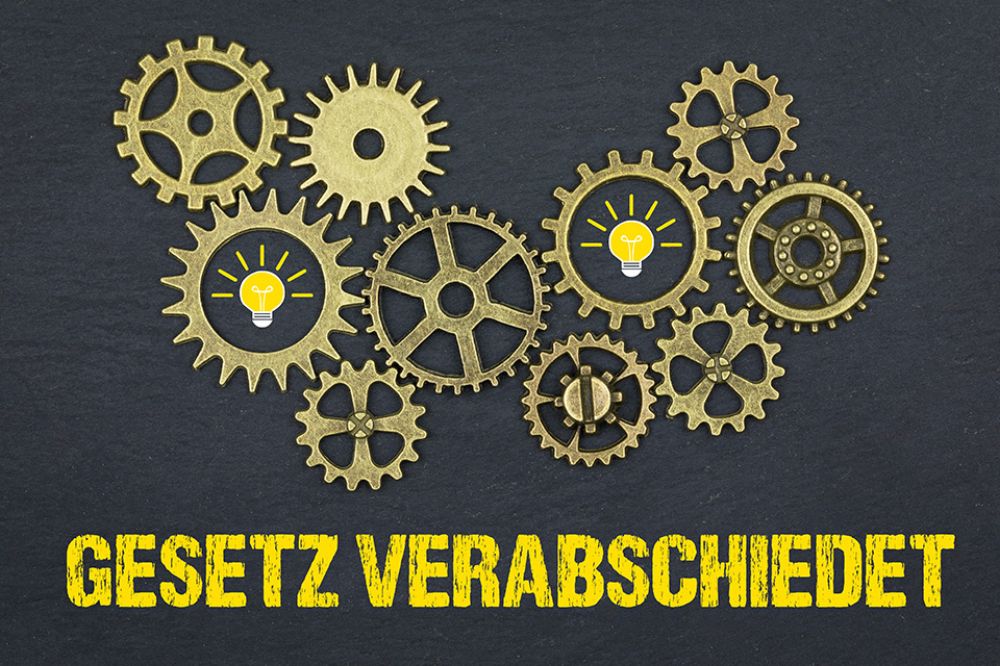 Zahnräder über Schriftzug GESETZ VERABSCHIEDET